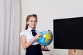 Schoolgirl girl studies globe at school on geography Royalty Free Stock Photo