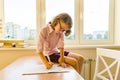 Schoolgirl, girl of 8 years, sitting at table with books and writing in notebook. School, education, knowledge and children. Royalty Free Stock Photo