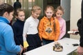 Schoolgirl girls are smiling and looking at a homemade car model