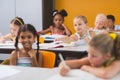 Schoolgirl giving chit to her friends in classroom