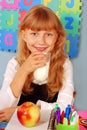 Schoolgirl with glass of milk and an apple