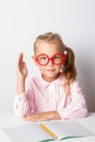 A schoolgirl with glasses at a table Royalty Free Stock Photo