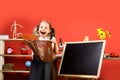 Schoolgirl with happy face and ponytails holds open schoolbag