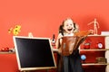 Schoolgirl with happy face and ponytails holds open schoolbag