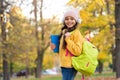 Schoolgirl hold books and school bag while walking in park, education Royalty Free Stock Photo