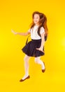 Schoolgirl jumping high over yellow background. Back to school. Happy girl ready to study with backpack Royalty Free Stock Photo