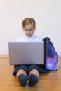 Schoolgirl with a laptop. the girl does exercises at a laptop. Girl with laptop on the floor. vertical photo Royalty Free Stock Photo