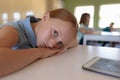 Schoolgirl leaning on her desk in an elementary school classroom Royalty Free Stock Photo