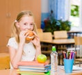 Schoolgirl looking at camera while having lunch during break Royalty Free Stock Photo