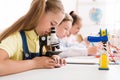 Schoolgirl looking at microscope at stem robotic class Royalty Free Stock Photo