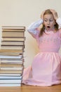 Schoolgirl is mad at books. The concept of hate to study and books. Unwillingness of a child to learn. Shock from the books. Shock Royalty Free Stock Photo