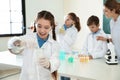 Schoolgirl making experiment with teacher and pupils in  class Royalty Free Stock Photo