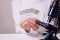 A schoolgirl with a microscope examines chemicals in test tubes, conducts experiments. The concept of coronavirus Royalty Free Stock Photo