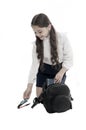 Schoolgirl packing backpack isolated on white. Little child put pen and book into bag. Pack backpack for lessons Royalty Free Stock Photo