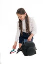 Schoolgirl packing backpack isolated on white. Little child put pen and book into bag. Pack backpack for lessons Royalty Free Stock Photo