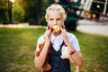 Schoolgirl with pigtails in uniform is eating an apple