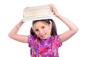 Schoolgirl with pile of books on head