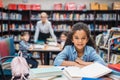 beautiful african american schoolgirl with pile of books