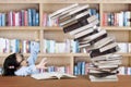 Schoolgirl with pile of books in the library