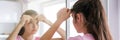 schoolgirl in pink t-shirt pops pimples reflecting in mirror