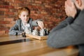 Schoolgirl playing chess with adult male person