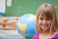 Schoolgirl posing in front of a globe