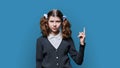 Preteen girl showing hand up, space for text, blue background