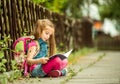 Schoolgirl reading a book on the street Royalty Free Stock Photo