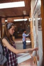 Schoolgirl reading notice board in corridor