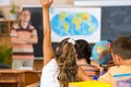 Schoolgirl rising her hand at geography lesson Royalty Free Stock Photo