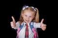 Schoolgirl showing thumbs up sign using both hands at the black Royalty Free Stock Photo