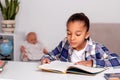 The schoolgirl siting at the table at home and doing his homework Royalty Free Stock Photo