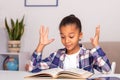 The schoolgirl sits at the table at home and does his homework Royalty Free Stock Photo