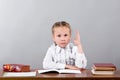 schoolgirl sitting at the desk raising her hand knowing the answer Royalty Free Stock Photo