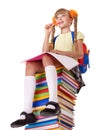 Schoolgirl sitting on pile of books.