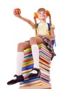 Schoolgirl sitting on pile of books.