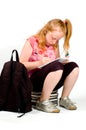 Schoolgirl sitting on a stack of books Royalty Free Stock Photo