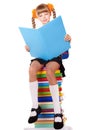 Schoolgirl sitting on stack of books.