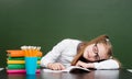 Schoolgirl sleeping on the book in classroom