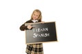 Schoolgirl smiling happy and cheerful holding and showing small blackboard with text I learn Spanish