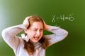 Schoolgirl solves a math problem on the blackboard during the lesson