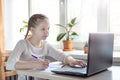 Schoolgirl studying at home using laptop. Home school, online education, home education, quarantine concept Royalty Free Stock Photo