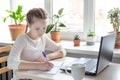 Schoolgirl studying at home using laptop. Home school  online education  home education  quarantine concept Royalty Free Stock Photo