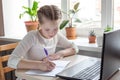 Schoolgirl studying at home using laptop. Home school online education home education quarantine concept