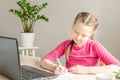 Schoolgirl studying at home using laptop. Home school, online education, home education, quarantine concept Royalty Free Stock Photo