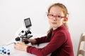 Schoolgirl with modern microscope