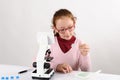 Schoolgirl with modern microscope