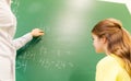 Schoolgirl and teacher with task on chalk board Royalty Free Stock Photo