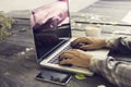 Schoolgirl typing on a laptop, with cell phone and coffee outdoors Royalty Free Stock Photo