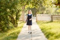 Schoolgirl in uniform with a backpack and books goes to school